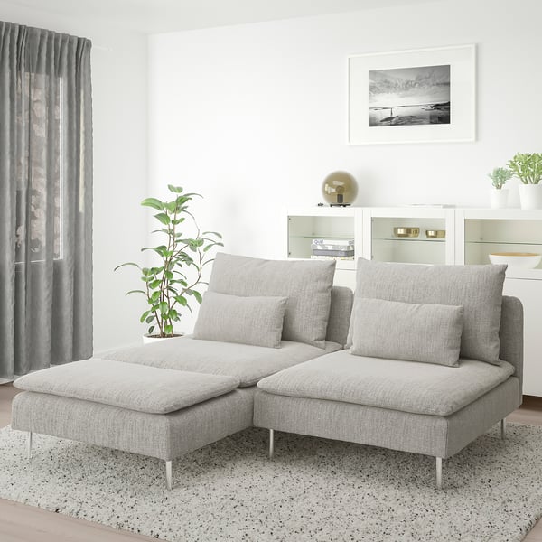 Modern minimalist living room: light grey SÖDERHAMN sectionals, large cushions, speckled rug, potted plant, curtained window, wall picture.