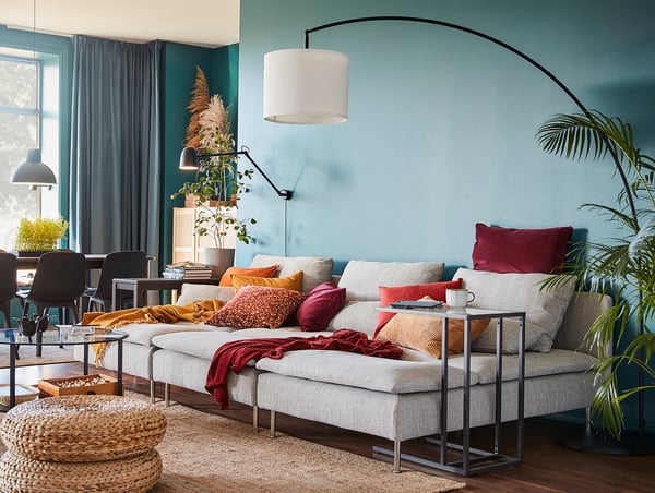 Cosy living room with teal walls, a SÖDERHAMN beige chaise longue, colourful pillows, and houseplants.