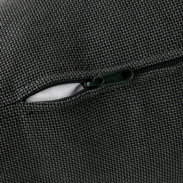 Close-up of a zip on a textured black sofa, showcasing quality fabric.