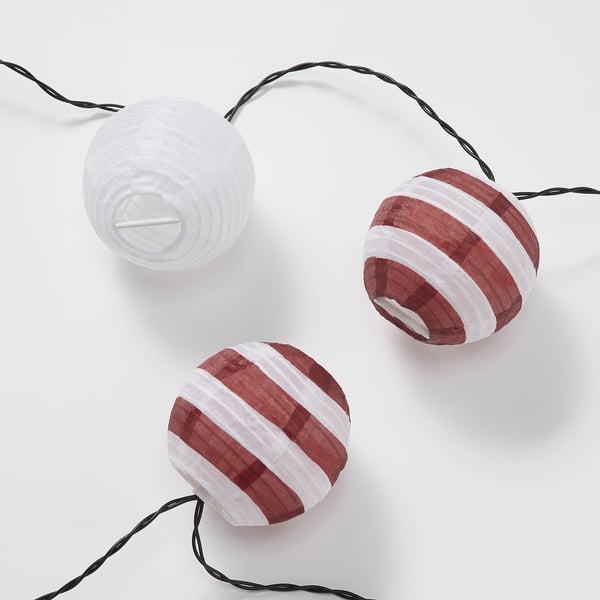 Three spherical hanging lights; two red and white striped, one plain white; attached by black cords, displayed against a white background.