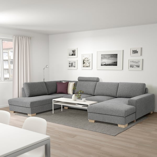 Modern grey l-shaped SÖRVALLEN sectional with colourful pillows & white coffee table in cosy living room.