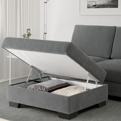 Everyday living room setup featuring grey SÖRVALLEN sofa with open footstool storage revealing blankets.