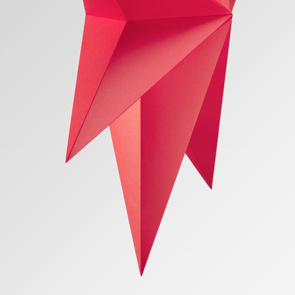 Red geometric lamp with sleek design, featuring sharp angles and vibrant red panels.
