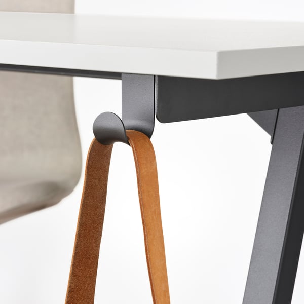 Desk with brown leather straps supporting its black metal frame, showcasing a stylish and sturdy design.