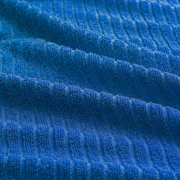 Close-up of soft, plush blue VÅGSJÖN cotton towel, highlighting its textured terrycloth quality.