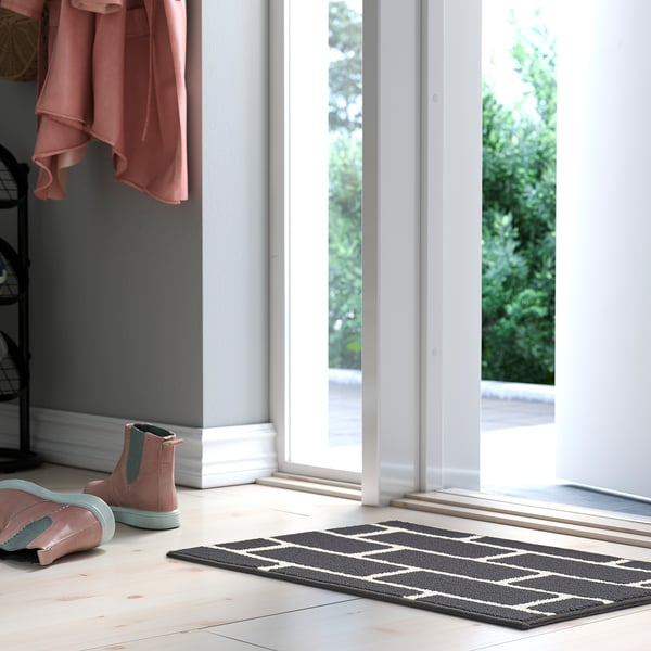 Grey & white geometric rug near doorway, polypropylene.