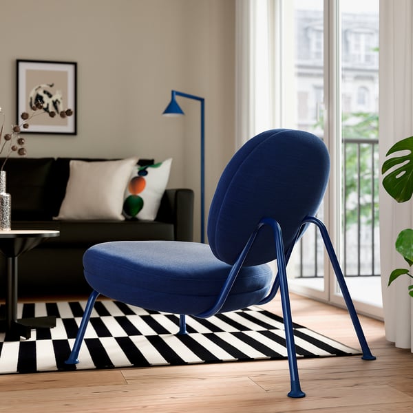 Blue VEINGE chair near window. Soft, large seat with removable cover for easy cleaning.