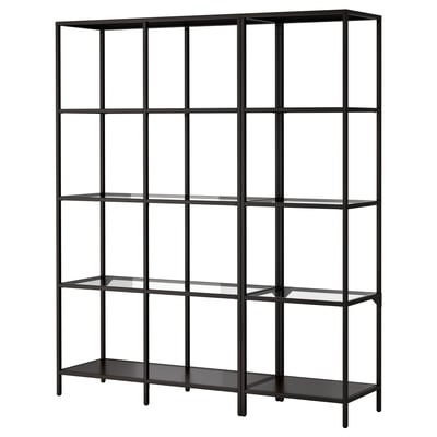 A VITTSJÖ black shelf, featuring five clear glass shelves and a black metal frame. Its minimalist design provides an open, airy feel.