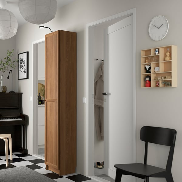 Minimalist hallway with BILLY bookcase, closet, clock, and black chair.