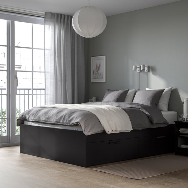 Modern bedroom with BRIMNES black bed, grey bedding, wall lights, and large window.