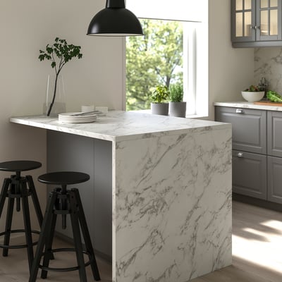 Modern kitchen with marble-patterned EKBACKEN island, black stools, hanging lamp, grey cabinets, and floral view through window.