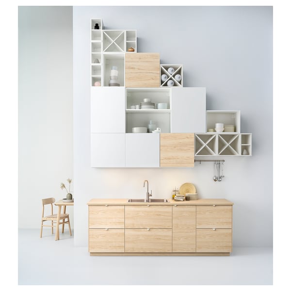 Modern kitchen setup with wooden EKBACKEN counter and shelves. White and light wood design. Sink, dishes, and dining furniture included.