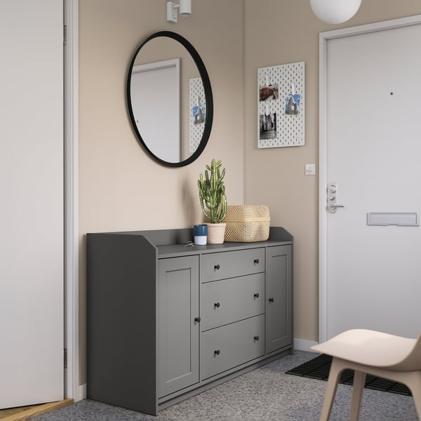Modern entryway with HAUGA grey sideboard, round mirror, plants, and pegboard.