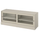 The HAVSTA tv bench, light beige, sliding glass doors and pine wood, offering a rustic yet modern design.