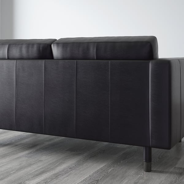 Modern sleek black sofa with clean lines, high legs, and smooth cushions.
