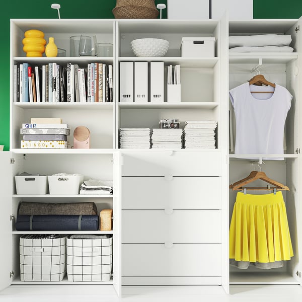 White wardrobe with shelves for storage, including books, boxes, and folded clothes. A yellow skirt hangs on the right side.
