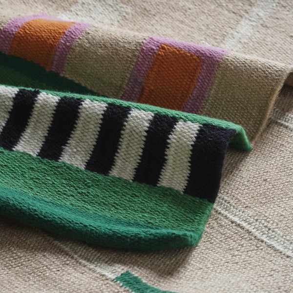 Vibrant, handwoven rug with jute and wool accents, showcasing bright colours and quality craftsmanship.