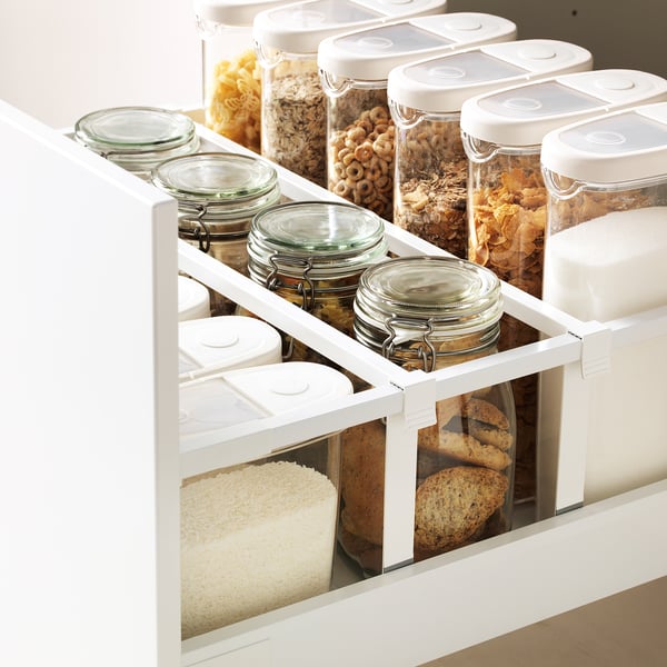 Kitchen drawer with organised dry foods in see-through containers and jars.