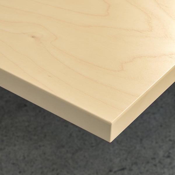 Close-up of light wood table surface, smooth and clean.