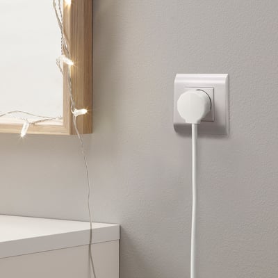 White power outlet with NYTTIG plug, wire, and lit lights.