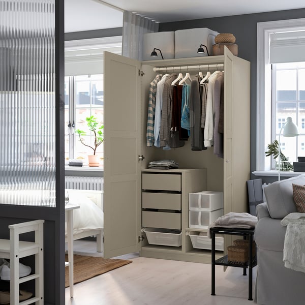 Open wardrobe displaying shirts, featuring hangers, drawers, and baskets for organised storage.