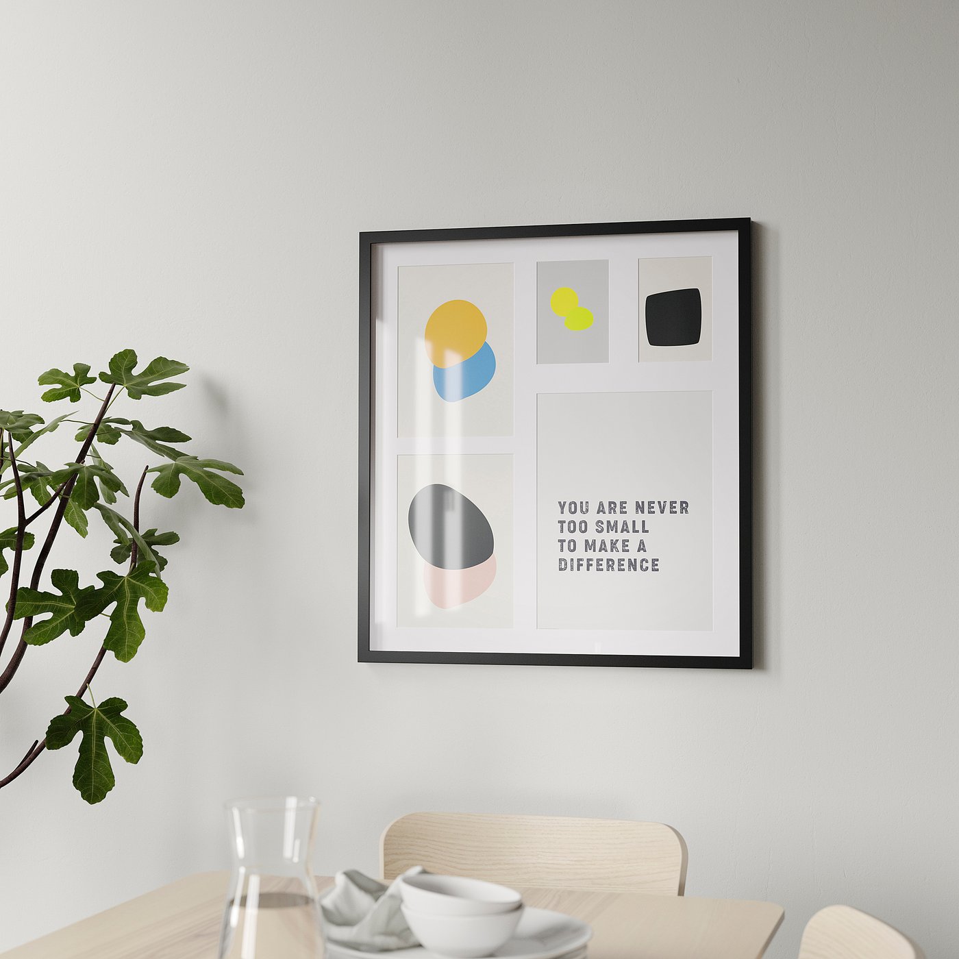 Framed motivational art with colourful shapes hangs on a wall above a wooden table with a glass and bowls. Plant on table left.