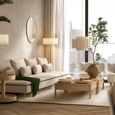 Modern living room with beige rug, cream sofa, wooden table, plants, mirror, and lamps.