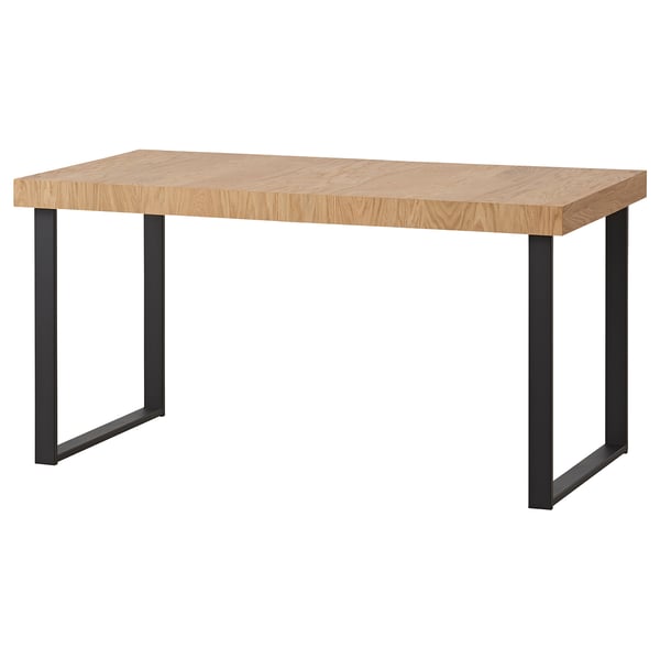 A TARSELE wooden dining table with metal legs. Its rectangular, light brown, and has an industrial design.