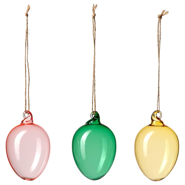 Three colourful glass ornaments hang in a row. Left: red-pink, middle: green, right: yellow. Each has a jute string loop at top.
