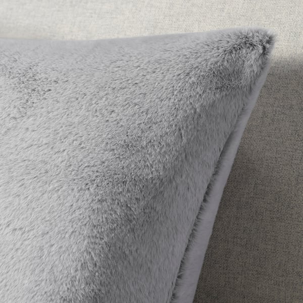 Soft, plush grey cushion with fluffy texture, made from recycled polyester, zip closure.