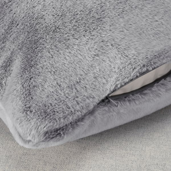 Close-up of soft, plush grey cushion with zip, showcasing luxury feel and quality.