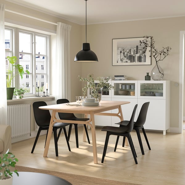 Modern dining area with VOXLÖV table, black chairs, and large window.