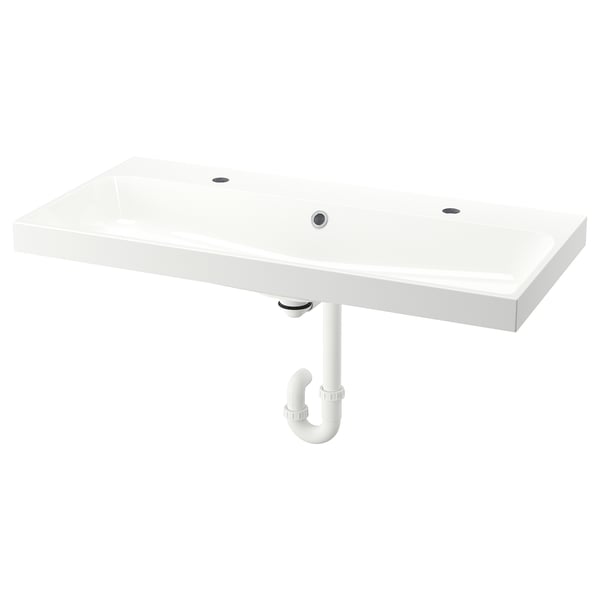 A white backsjon marble sink, rectangular, wall-mounted with a single tap hole and under-sink plumbing.
