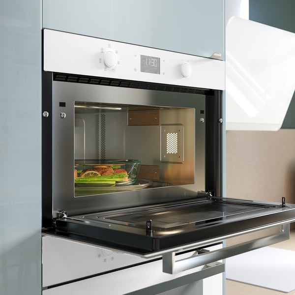Modern white built-in microwave oven with control panel, open door revealing glass dish inside.