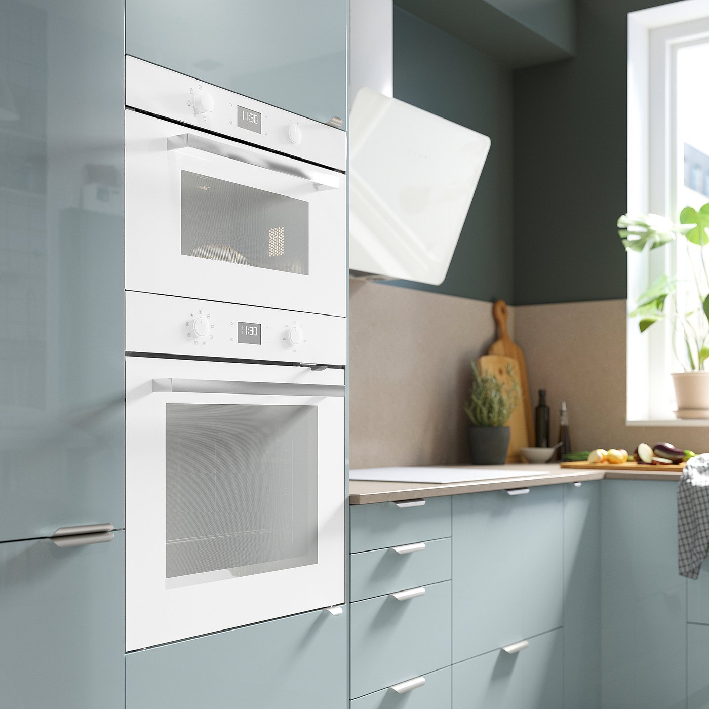 Modern kitchen with white double oven, microwave, blue cabinets, and range hood.