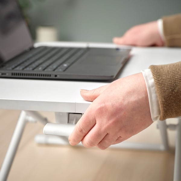 Person adjusting DUBBLA laptop stands height for ergonomic position change.