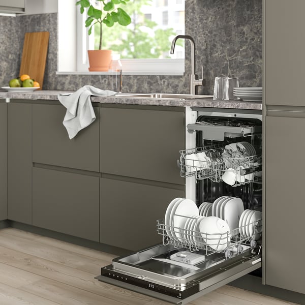Modern kitchen with compact FRÖSLUNDA dishwasher under dark cabinets, showcasing its efficient, narrow design and organised racks.