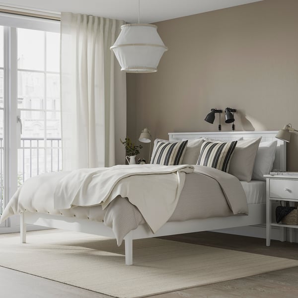 Modern bedroom white GULLABERG bed with a traditional design. The bed is large, surrounded by nightstands. Soft lighting enhances the serene ambiance.