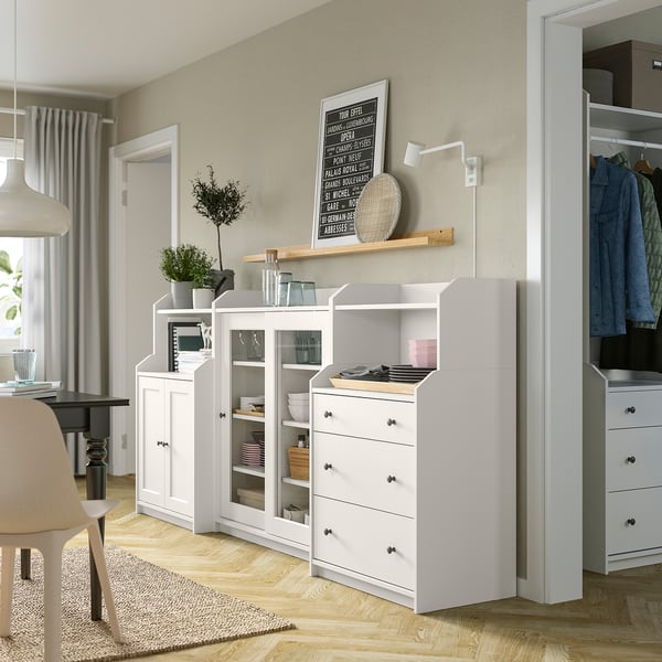 Cosy living room with white HAUGA storage units. Three drawers, glass doors, shelves for storing items.