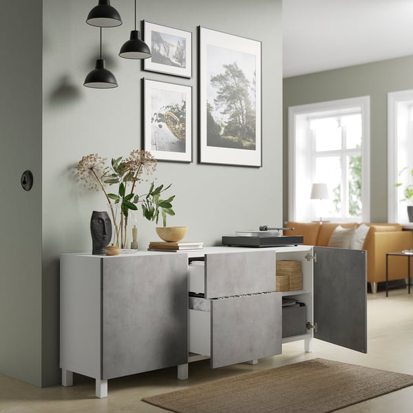 Modern cabinet with open door showing storage compartments. Concrete effect surface. Hangs from the ceiling with black lamps.
