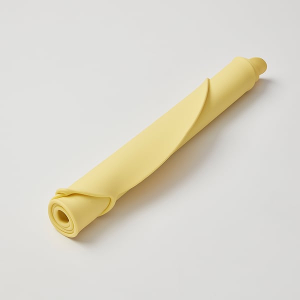 Yellow silicone placemat rolled up with a loop on top, designed for kids mealtimes.