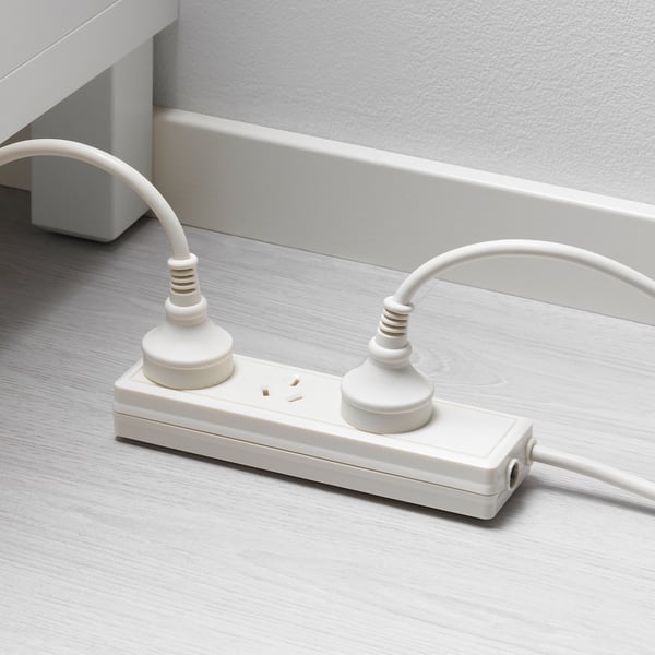 White extension cord with two plugs and two outlets on a wooden floor.