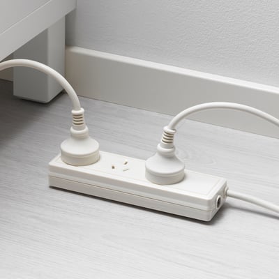White extension cord with two plugs and two outlets on a wooden floor.