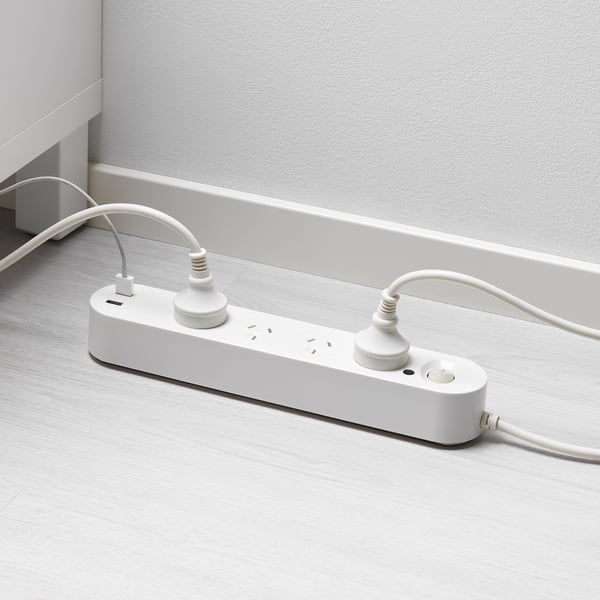 White floor socket with usb ports, two cables plugged in.