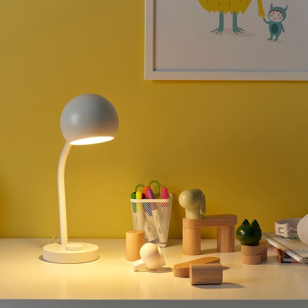 Korvsnore lamp: round, white, flexible neck, soft light; brightens desk space with playful accessories.