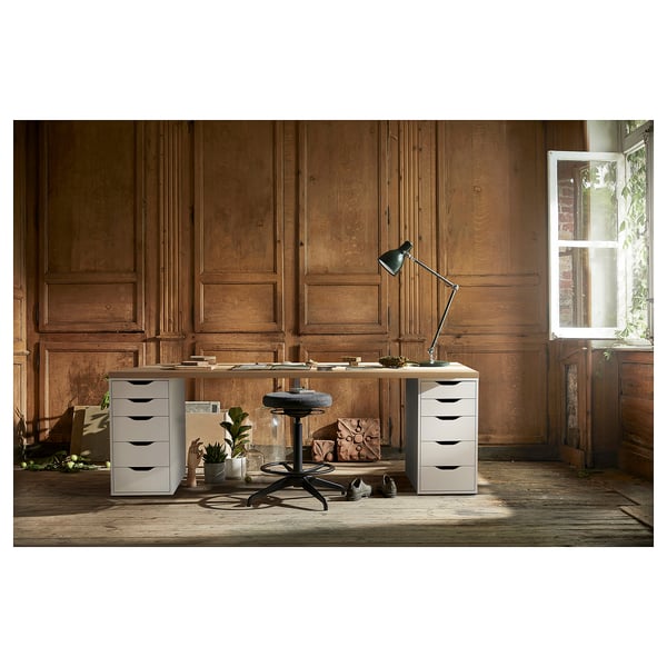 Home office setup: LAGKAPTEN desk in white with drawers, wooden walls, lamp, chair, plants.