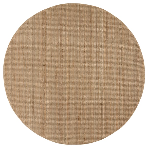 A circular, natural-colored jute rug named LOHALS. Its neutral tones create a calm atmosphere.