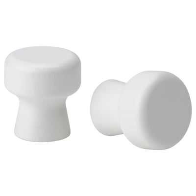 Two white, rounded furniture knobs; one tall and cylindrical, the other spherical and attached to a smaller base.