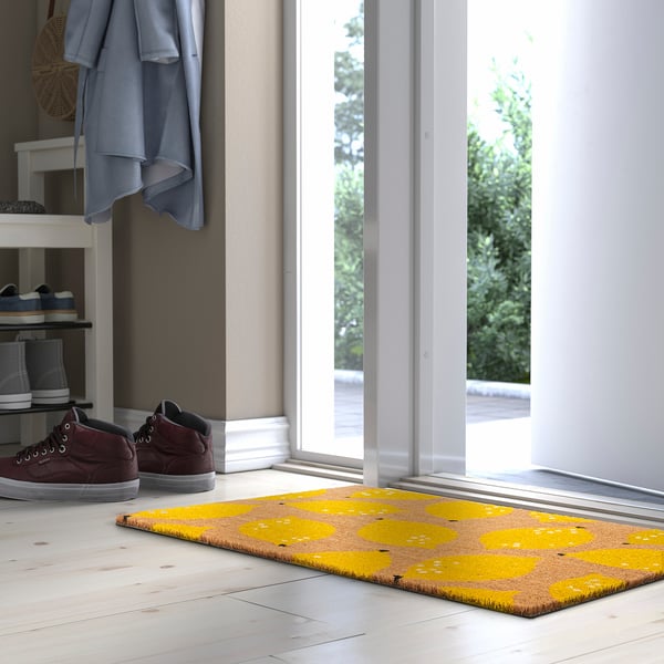 Bright yellow RENKAVLE mat with lemon design at entrance, large size, fits by doorway, made of coir.