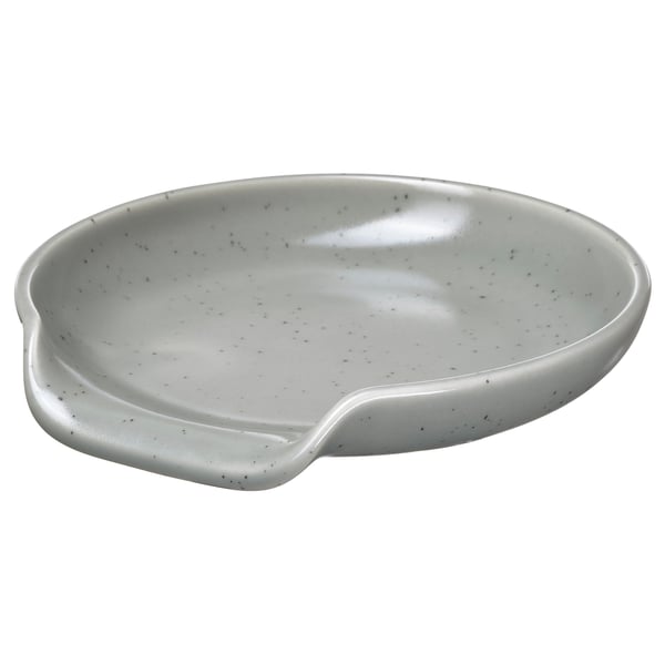 White RÖDSYRA ceramic spoon rest with dotty glaze, oval shape, ergonomic handle.
